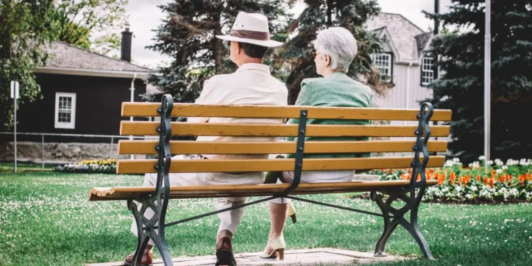 two seniors sitting on a bench together