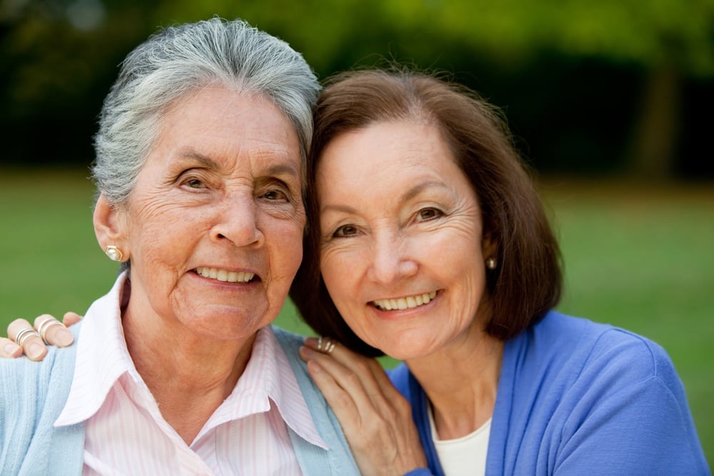 Portrait of an elder mother and daughter smiling outdoors.jpeg