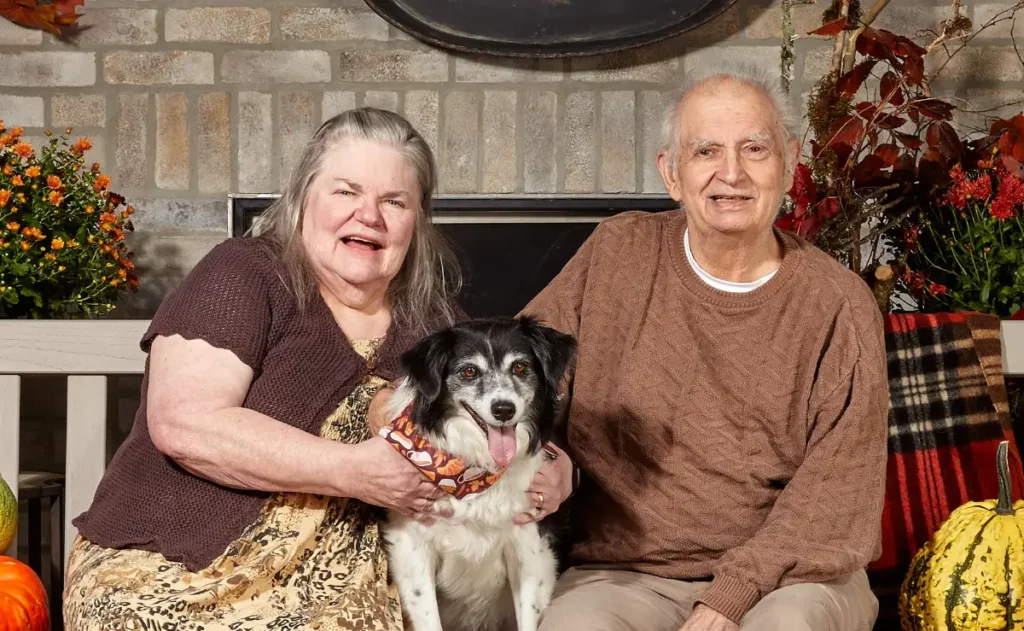 elderly couple with dog on lap