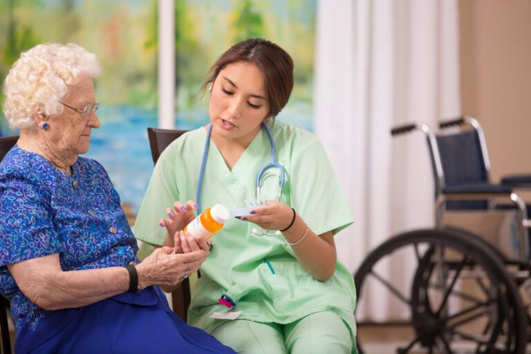 nurse helping elderly woman with medication