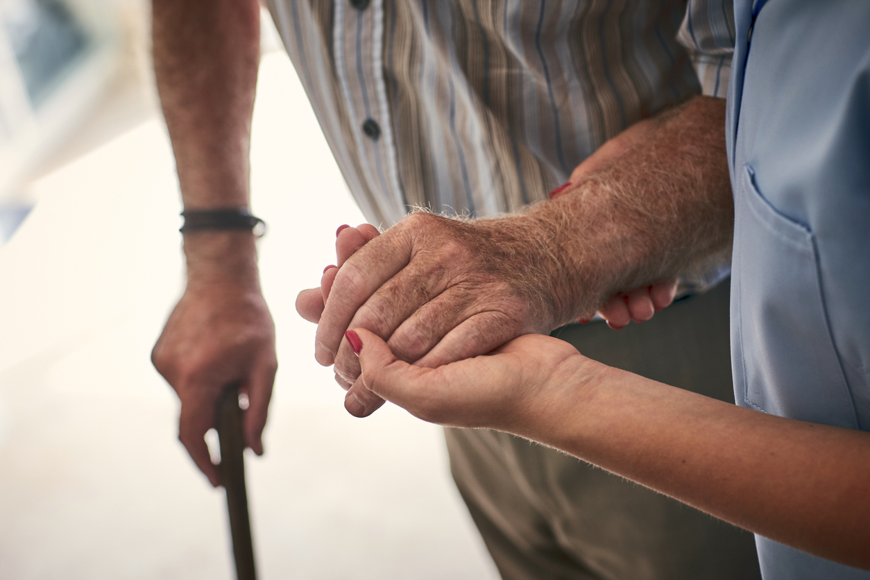 Woman helping a man in long term senior care